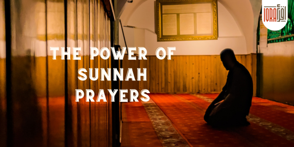 Man in traditional attire praying inside a mosque with beautifully designed interiors.